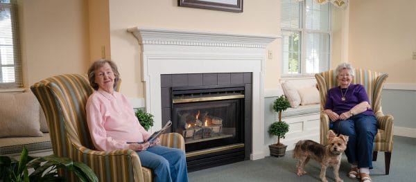 Residents of Mennowood Retirement Community reading by the fireplace