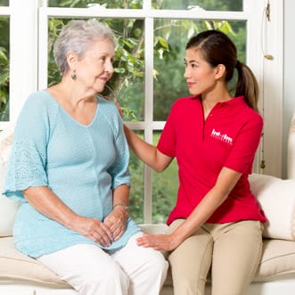 Interim - Tucson female caregiver with her arm on senior woman's shoulder