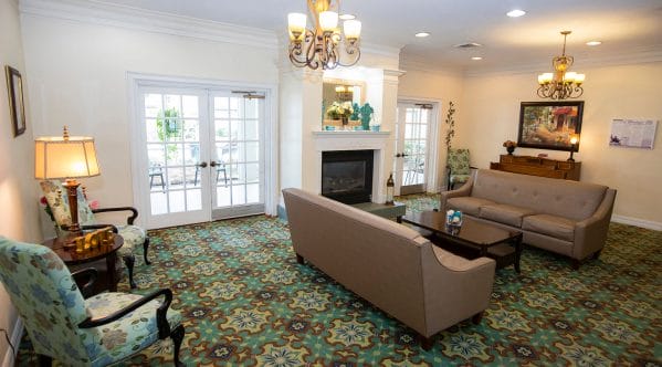Savannah Cove of Maitland resident living room with facing sofas and french doors on both sides of the fireplace