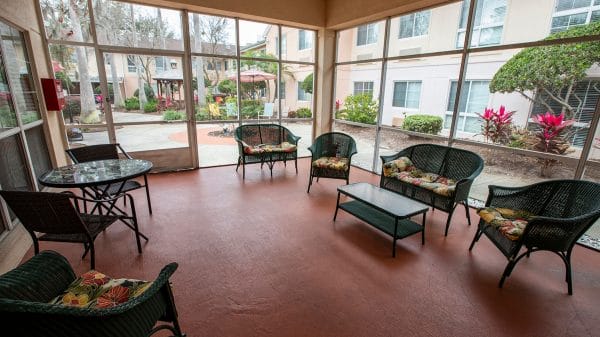 Savannah Court of Maitland sunroom with wicker seating and large views of the courtyard