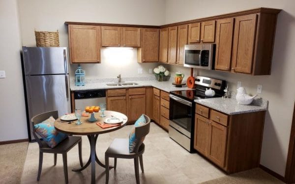 Resident kitchen with oak cabinets and stainless steel appliances at Sable Lodge Retirement