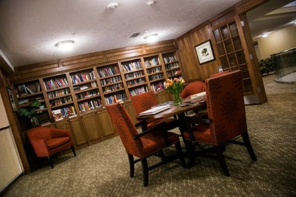 Sherrill Hills Retirement library with built in wooden bookshelves and cozy reading areas and tables
