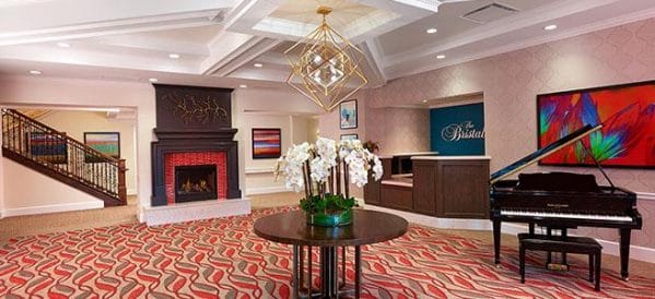 The Bristal Assisted Living at Garden City lobby with reception desk, fireplace and coffered ceiling