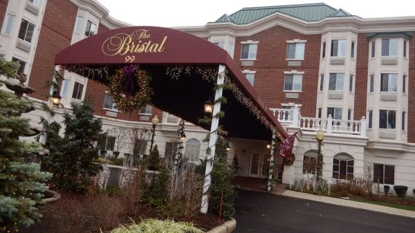 Maroon awning covering the driveway and entrance to The Bristal Assisted Living at North Hills