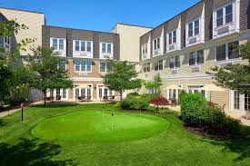 The Bristal Assisted Living at North Woodmere rear cortyard with lush green lawn and manicured hedges