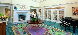 The Bristal Assisted Living at North Woodmere lobby with grand piano, fireplace and white french doors