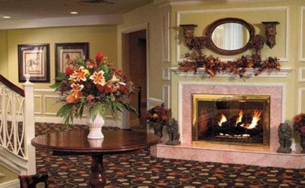 The Bristal Assisted Living at Westbury common area with cozy surroundings and roaring fire
