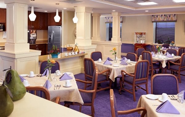 Dining room with purple rug and cream walls at The Bristal Assisted Living at White Plains