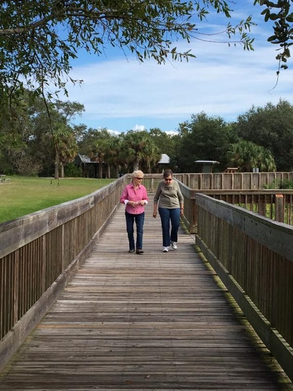 Two senior women walking on boardwalk at The Oaks of Clearwater