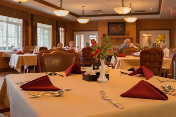 Resident dining hall at Lake Pointe Landing with white linens