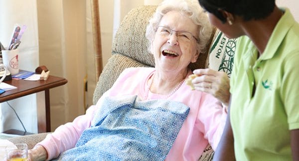 Senior woman laughing with caregiver