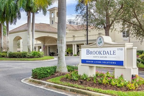 Welcome sign in front of the covered driveway and entrance to Brookdale North Naples
