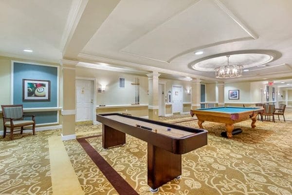 Tabletop shuffleboard and pool table in the Brookdale North Naples game room