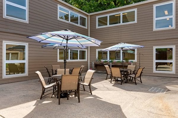 Brookdale Pleasant Hills patio with umbrella tables and seating for residents