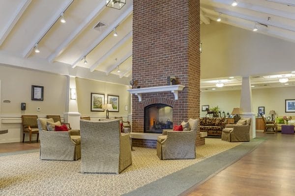 Community living room with towering fireplace in Brookdale University Park