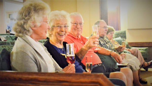 Senior residents at Copper Springs Retirement cheering with flutes of champagne