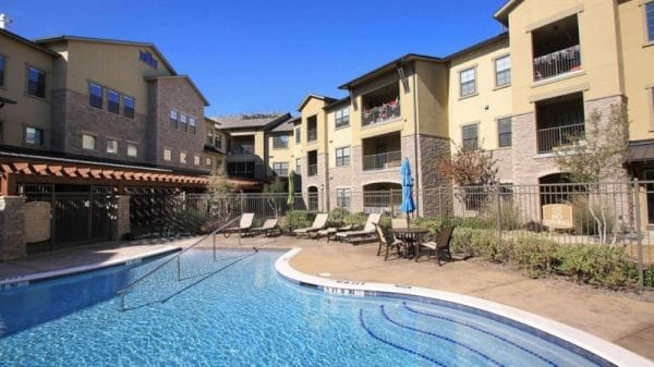 Outdoor swimming pool with walk in entry and lounging area at Discovery Village At Twin Creeks