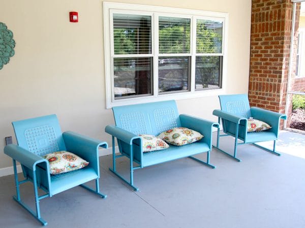 Blue chairs on a porch at Regency Retirement Village - Huntsville