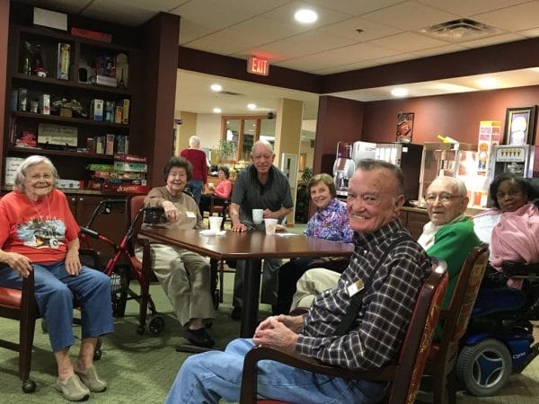 Group of senior Robinwood Retirement residents seated around a table and smiling