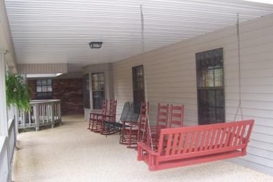 Covered porch with swing and rocking chairs at Green Oaks Inn
