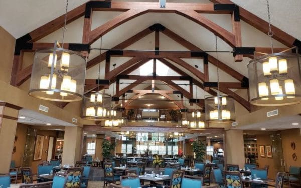 Catherdral ceilings with large exposed wooden trusses over open dining room at Stone River Retirement