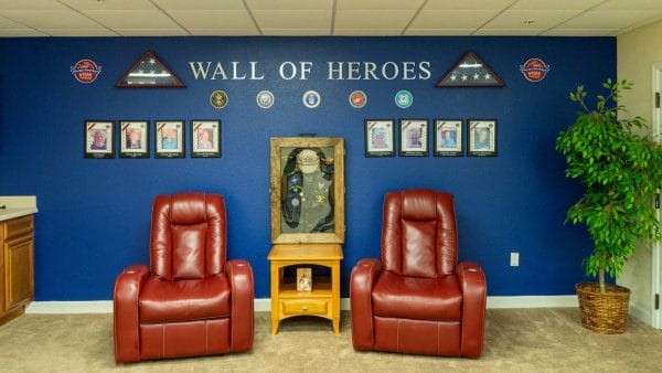 Red leather recliner chairs in front of the Sunflower Springs - Homosassa wall of heroes