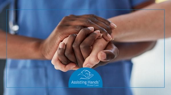 Caregiver and senior hands held together