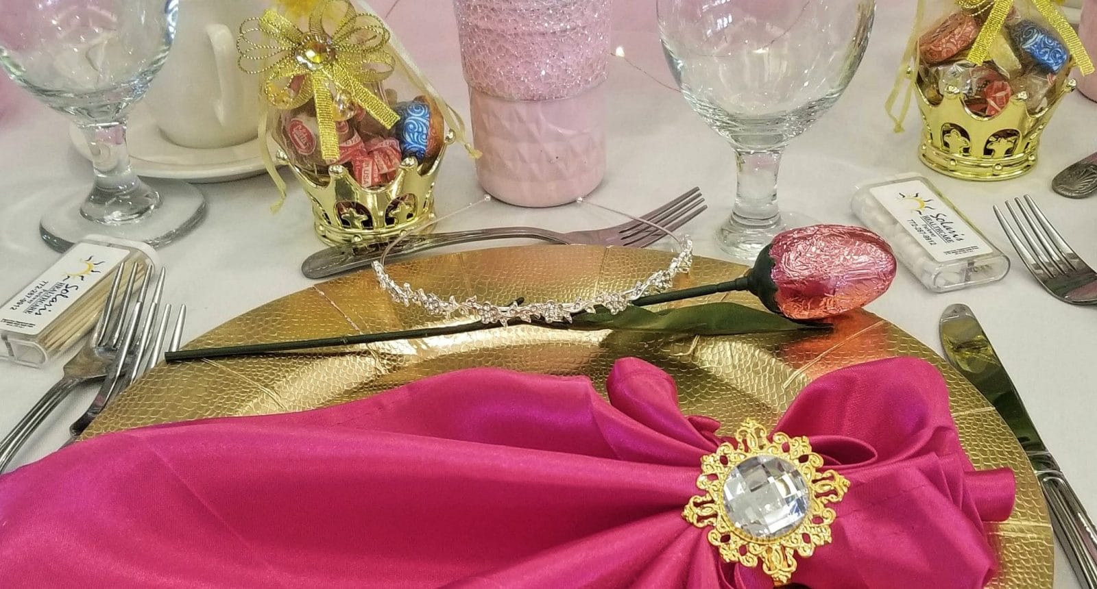 Table setting with pink napkin over gold plate