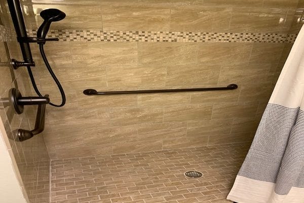 Walk in shower and handrail in a Discovery Village At Stuart model bathroom