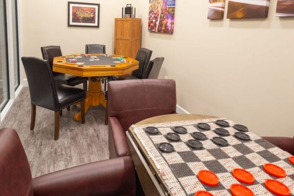 Checkers and poker table in the The Club at Boynton Beach game room