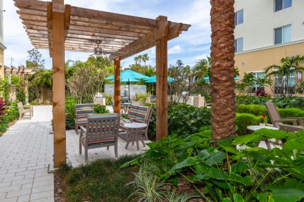 The Club at Boynton Beach outdoor patio with trellis and resident seating area