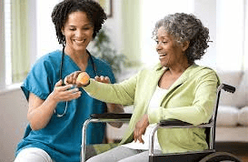 VIP Homecare Solutions caregiver helping sitting senior woman with physical therapy