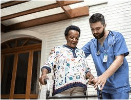 Male VIP Homecare Solutions caregiver assisting senior woman in walker