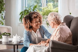 VIP Homecare Solutions caregiver talking with senior woman in chair
