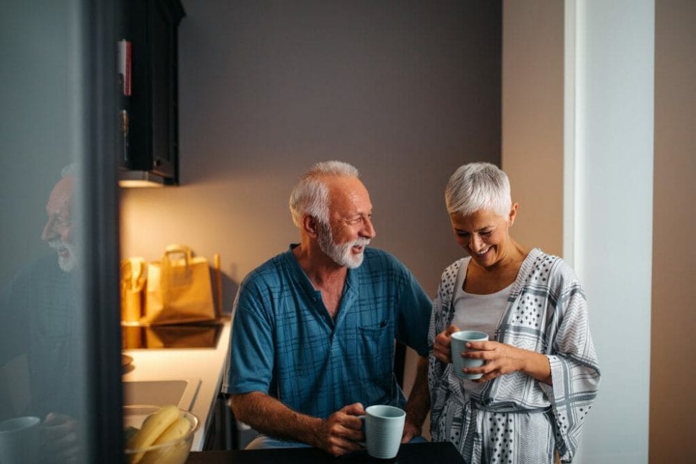Senior couple maintaining independence while drinking coffee and smiling