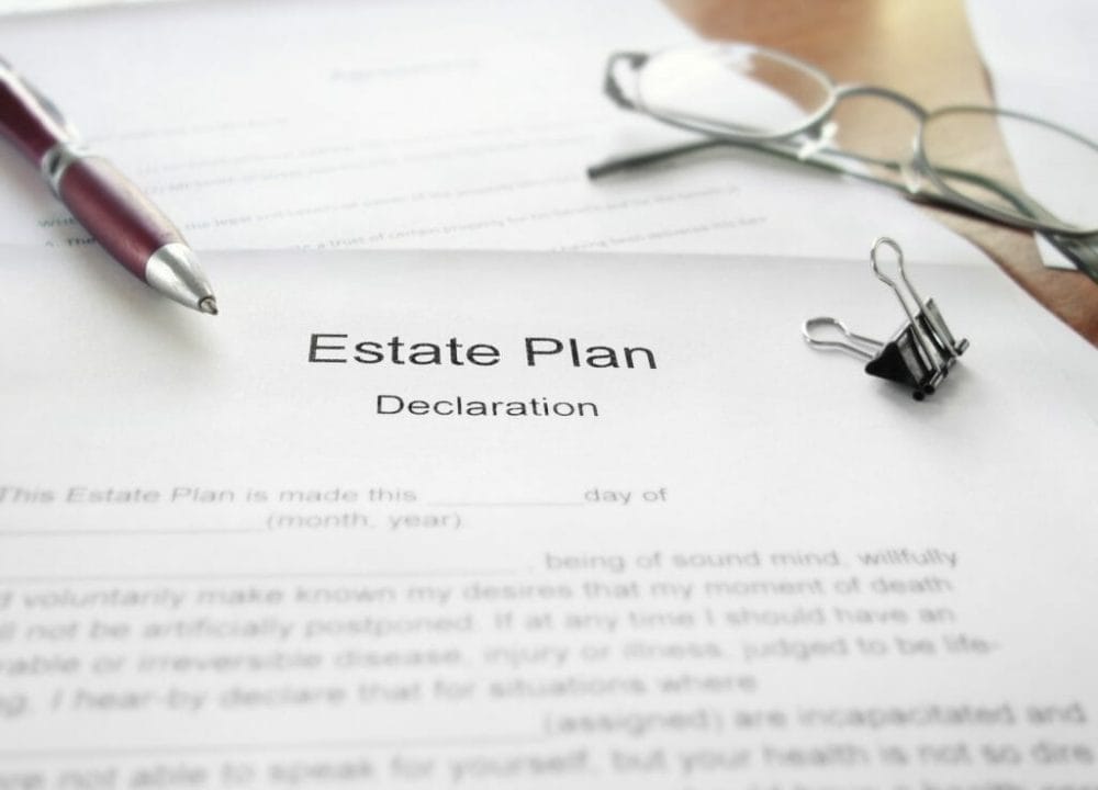 Estate Plan document on a desk with glasses and pen