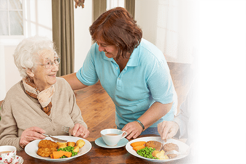 Around the Clock Home Care caregiver serving a meal to a senior couple
