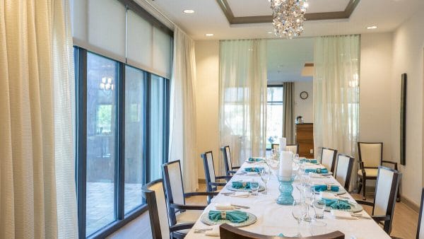 Private dining room with floor to ceiling windows and a long dining table in Seaside at Fort Myers