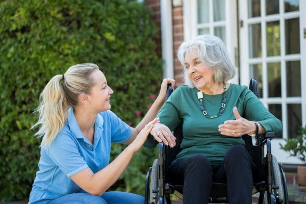 woman in wheelchair talking with a female caregiver